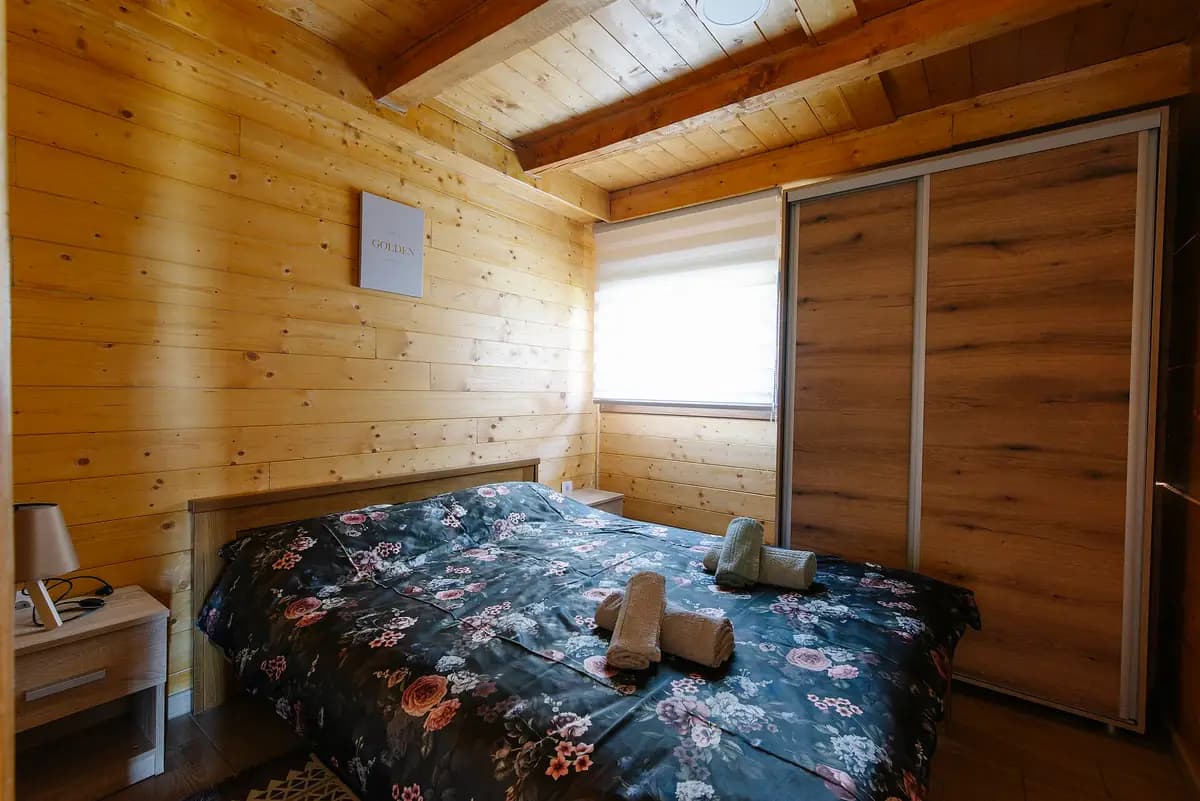 A cosy wood-panelled homestay room with a double bed